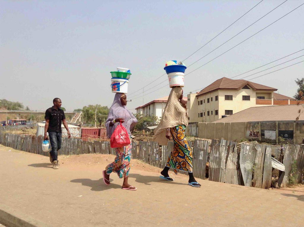 Street hawkers selling goods on a busy road in Abuja.